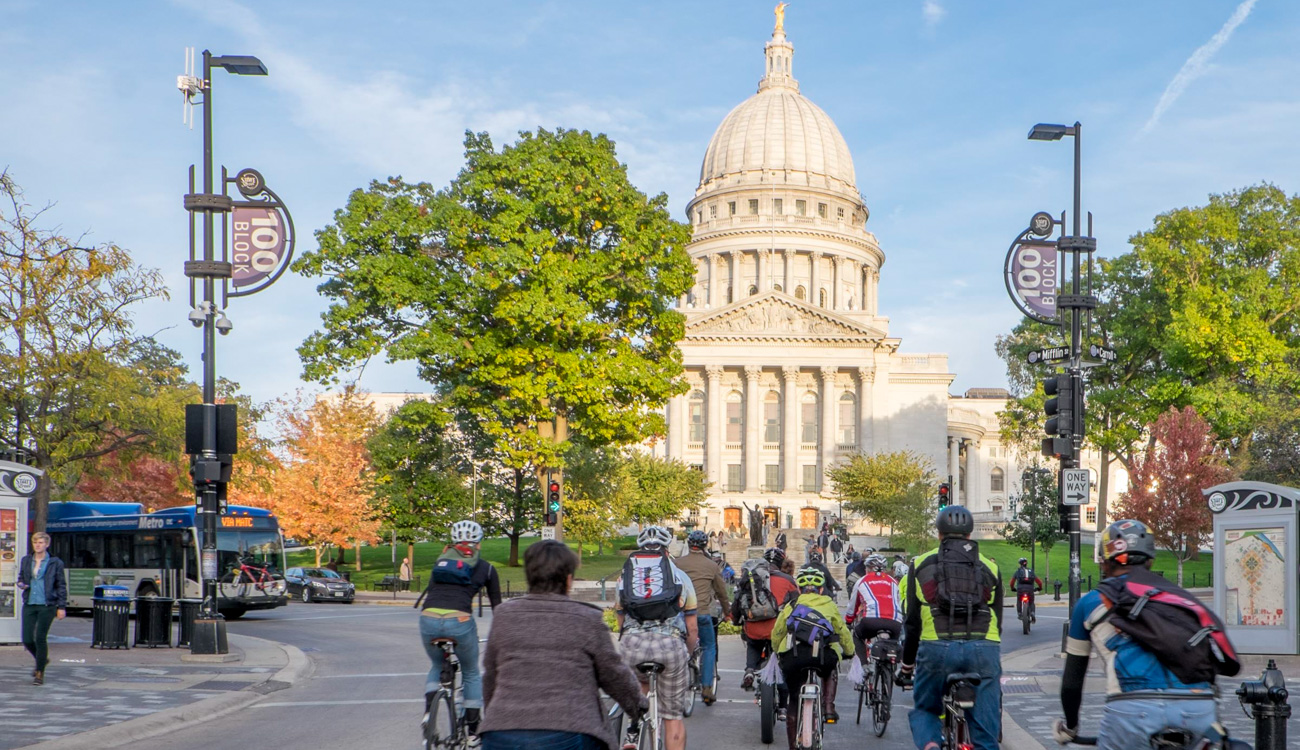 Wisconsin's capital square with sidewalks, bikes and a bus